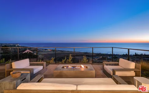 a view of a roof deck with couches and sky view