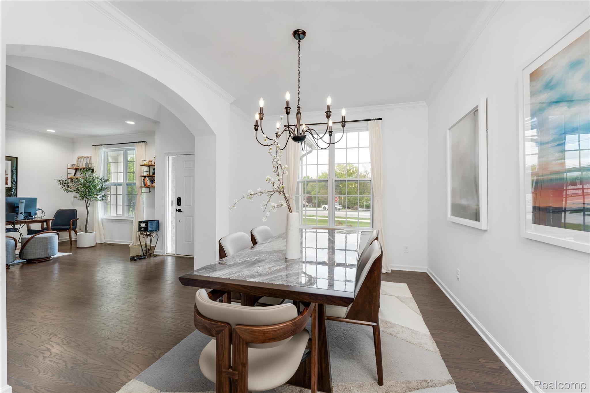 908 South Livernois Road Rochester, MI 48309 - Photo 5 of 49 Dining area featuring arched walkways, dark wood finished floors, suspended lighting, and crown molding