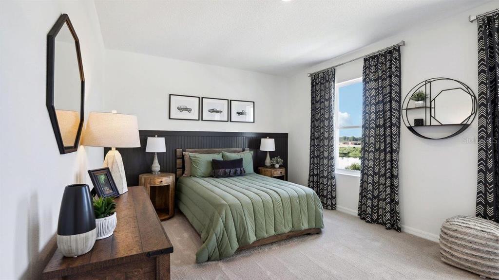 2306 Rikkola Lane Wesley Chapel, FL 33543 - Photo 12 of 28 a bedroom with a bed a mirror and dresser with wooden floor