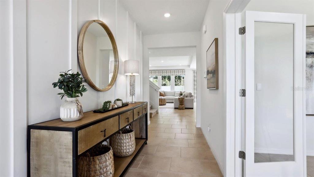 2306 Rikkola Lane Wesley Chapel, FL 33543 - Photo 2 of 28 a living room with furniture a mirror and a wooden floor