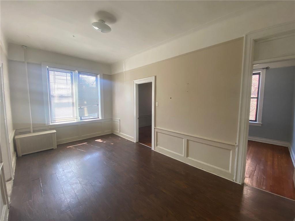 1175 66th Street Brooklyn, NY 11219 - Photo 6 of 17 an empty room with wooden floor and windows