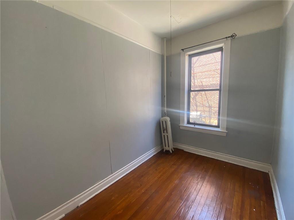 1175 66th Street Brooklyn, NY 11219 - Photo 9 of 17 an empty room with wooden floor and windows