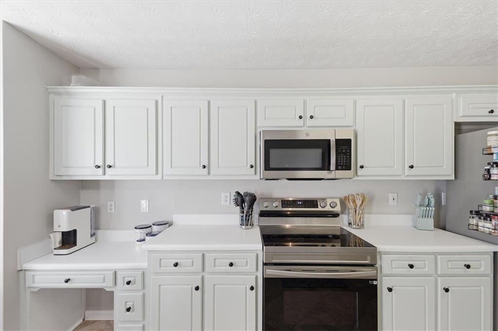 493 Youth Jersey Road Covington, GA 30014 - Photo 16 of 52 a kitchen with white cabinets and white appliances