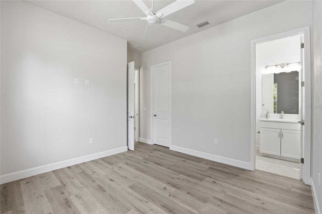 13425 Southwest 9th Road Newberry, FL 32669 - Photo 26 of 46 an empty room with wooden floor and a bathroom