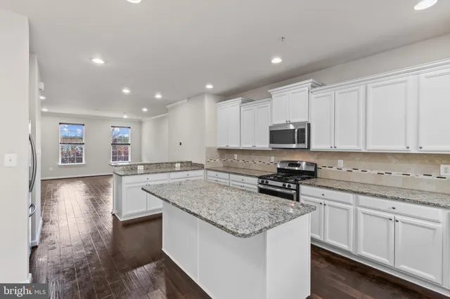 a kitchen with granite countertop a sink stove and cabinets