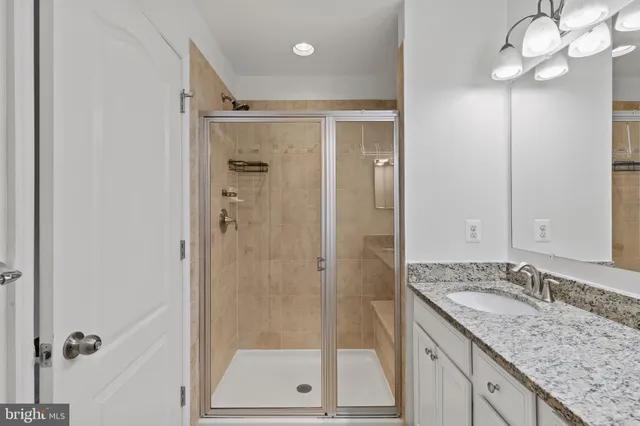 a bathroom with a granite countertop sink mirror and shower