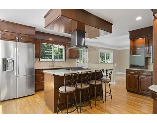 66 Broken Tree Road Newton, MA 02459 - Photo 11 of 26 a kitchen with stainless steel appliances kitchen island granite countertop a table chairs and a refrigerator