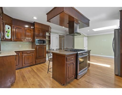 66 Broken Tree Road Newton, MA 02459 - Photo 12 of 26 a kitchen with stainless steel appliances kitchen island granite countertop a stove a refrigerator and a cabinets with wooden floor