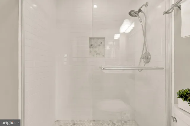 a bathroom with a glass shower door and a mirror