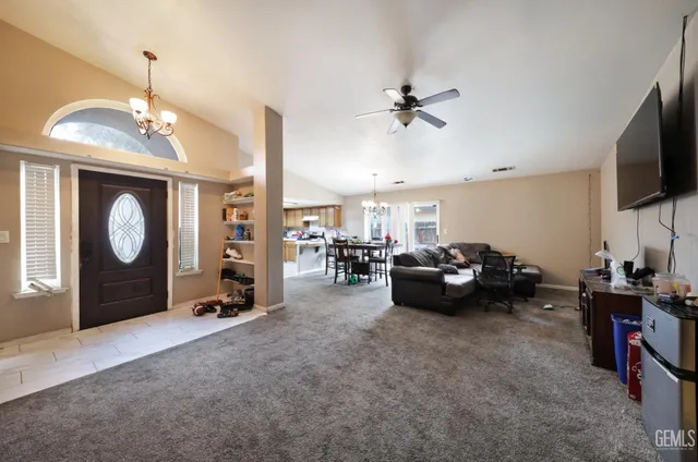 a living room with furniture a flat screen tv and a window