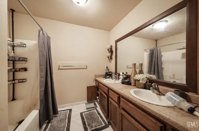 a bathroom with a double vanity sink a mirror and shower