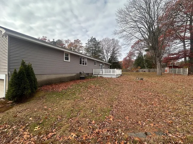 a backyard of a house with large trees and barbeque oven