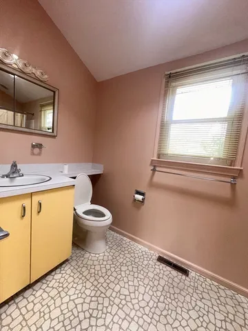 a bathroom with a granite countertop toilet a sink and a mirror