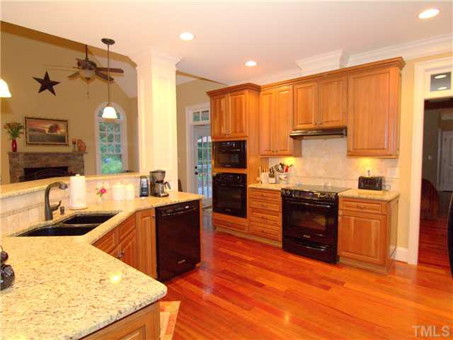 96 Avalant Pittsboro, NC 27312 - Photo 4 of 25 a kitchen with stainless steel appliances kitchen island granite countertop a refrigerator a stove top oven and a sink with wooden floor