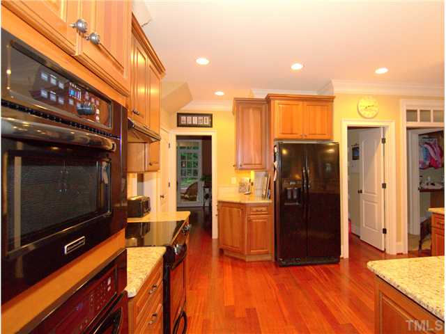 96 Avalant Pittsboro, NC 27312 - Photo 6 of 25 a kitchen with stainless steel appliances kitchen island granite countertop a refrigerator a stove and oven with wooden floor