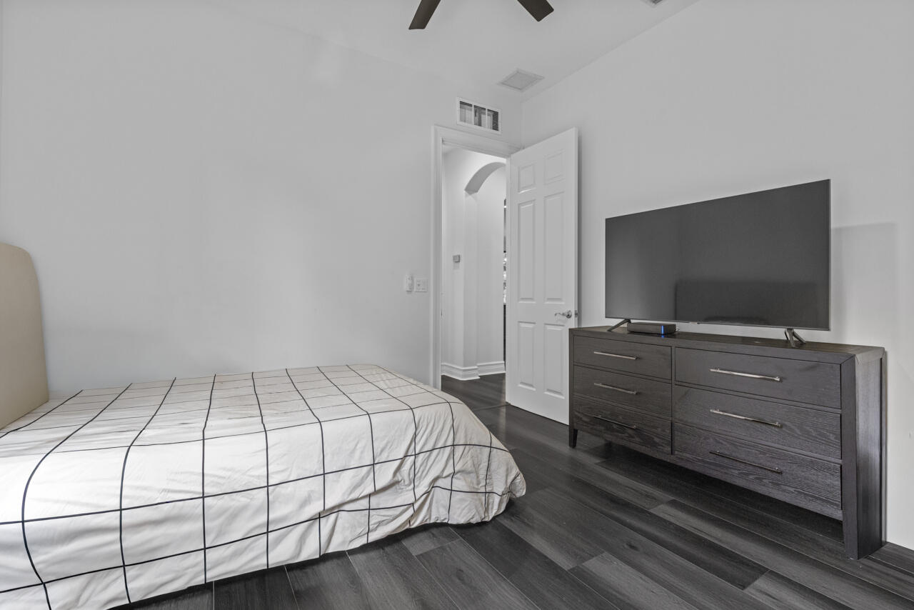 8300 Southwest Cattleya Drive Stuart, FL 34997 - Photo 30 of 77 a bedroom with a bed and a flat screen tv