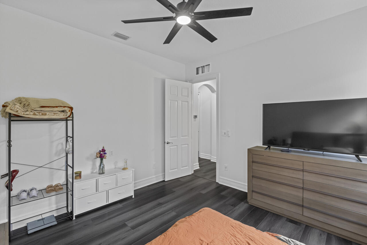 8300 Southwest Cattleya Drive Stuart, FL 34997 - Photo 33 of 77 a bedroom with furniture and flat screen tv