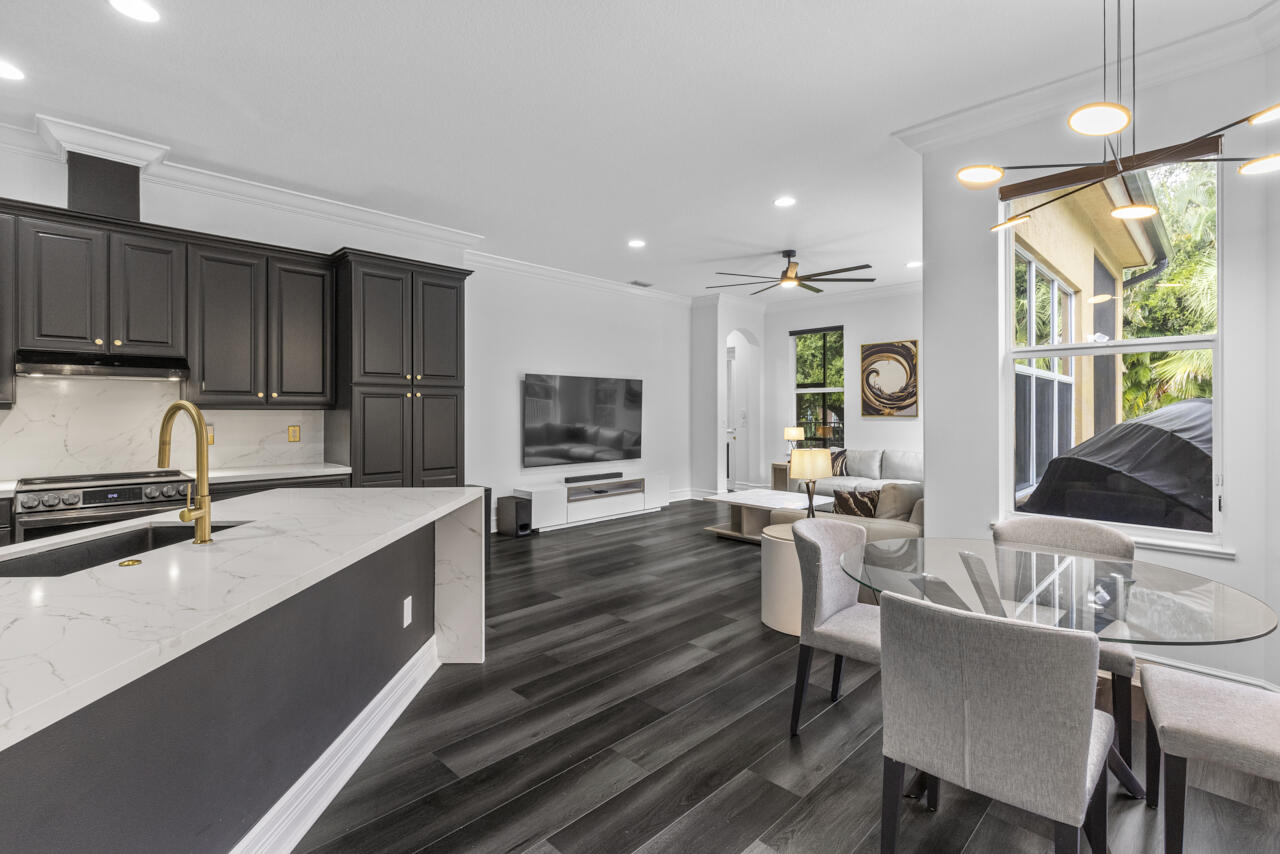 8300 Southwest Cattleya Drive Stuart, FL 34997 - Photo 39 of 77 a kitchen with a table chairs stove and cabinets