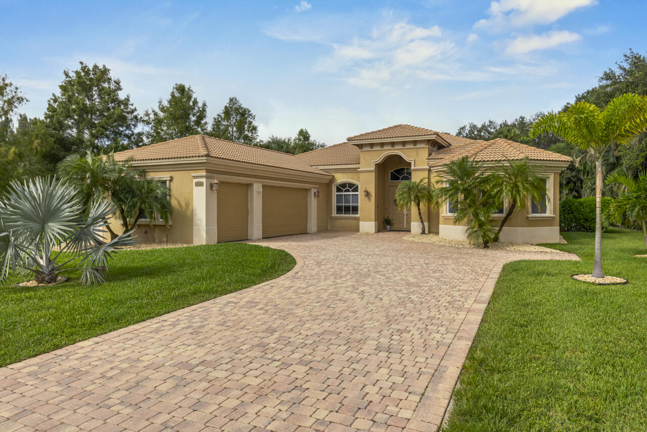 8300 Southwest Cattleya Drive Stuart, FL 34997 - Photo 4 of 77 a front view of a house with garden