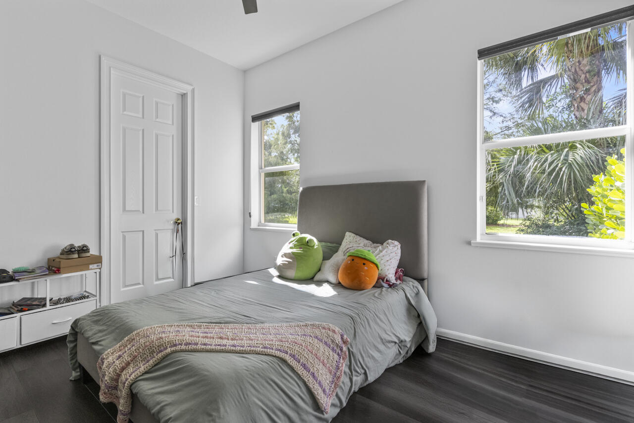 8300 Southwest Cattleya Drive Stuart, FL 34997 - Photo 43 of 77 a bedroom with a bed a lamp and a window