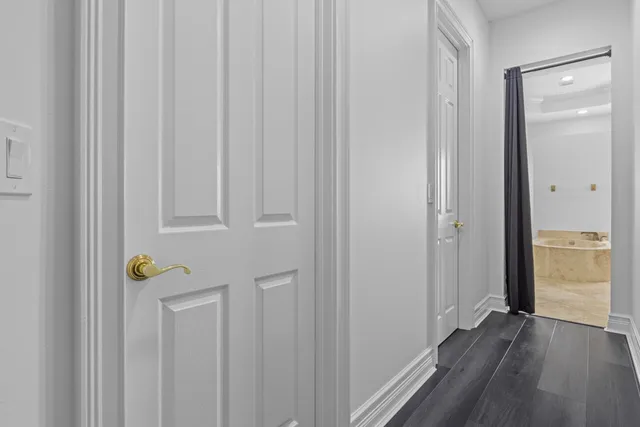 a view of a hallway with wooden floor and closet