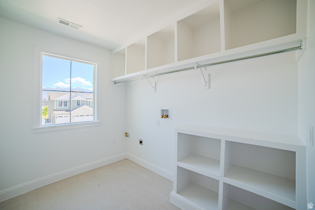 45 North Scarlet Maple Road, Unit 4317 Vineyard, UT 84059 - Photo 24 of 35 Bright utility room featuring a large window, extensive built-in shelving, a clothes hanging rod, and essential appliance hookups