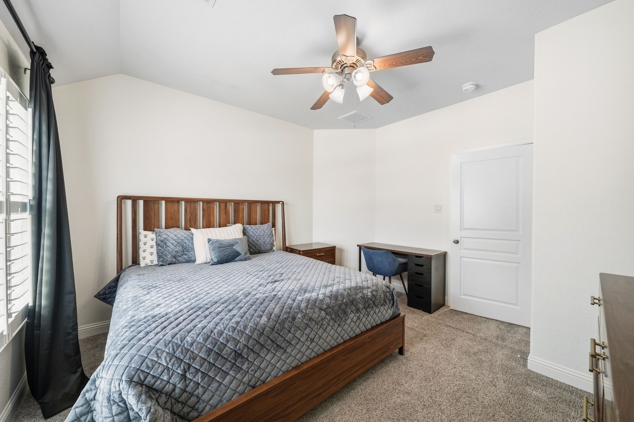 17610 Strackfield Lane Tomball, TX 77377 - Photo 36 of 50 Soft natural light filters through elegant plantation shutters, while a ceiling fan with integrated light enhances the inviting atmosphere of this peaceful third-bedroom retreat.
