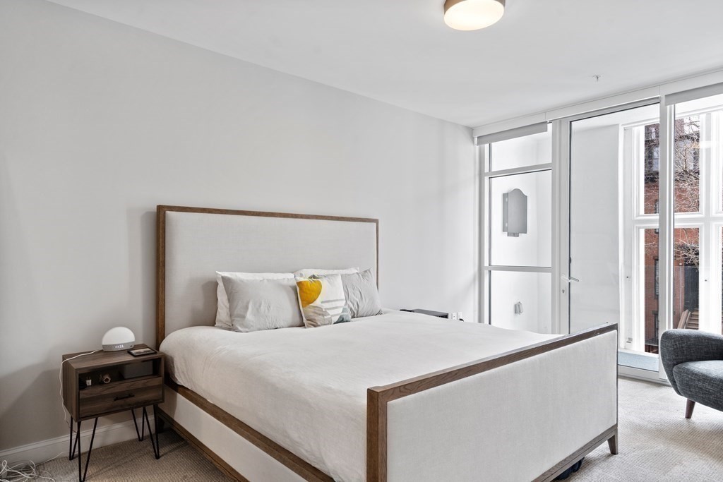 771 Harrison Avenue, Unit 207 Boston, MA 02118 - Photo 8 of 28 a bedroom with a bed and wooden floor