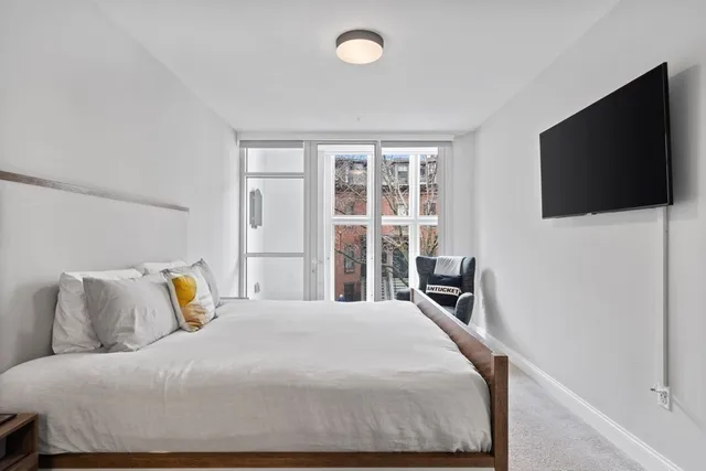 a bedroom with a large bed and a flat screen tv