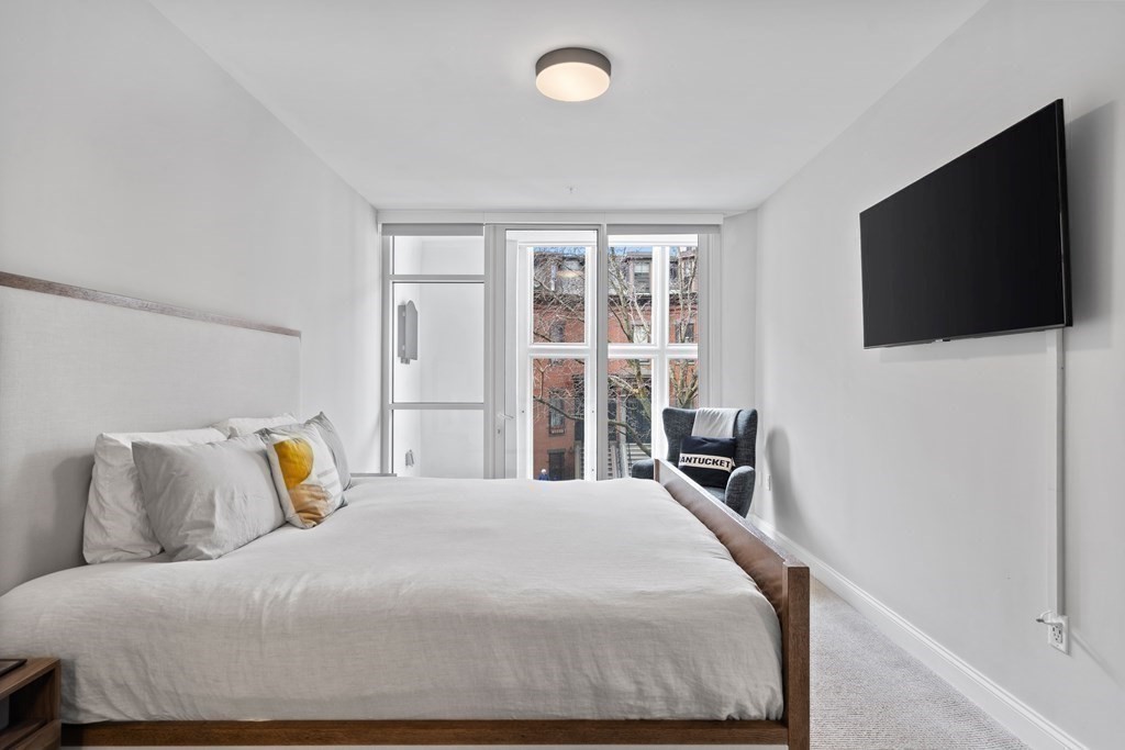 771 Harrison Avenue, Unit 207 Boston, MA 02118 - Photo 9 of 28 a bedroom with a large bed and a flat screen tv