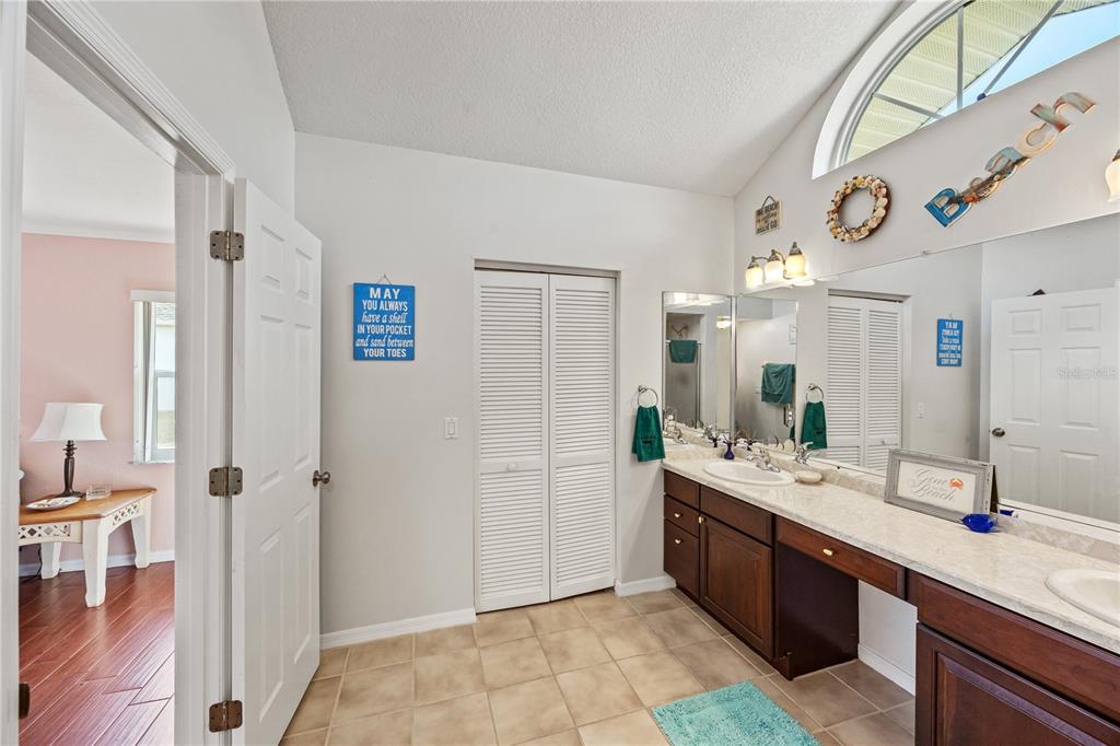 26223 Barcelos Court Punta Gorda, FL 33983 - Photo 19 of 34 a spacious bathroom with a double vanity sink a mirror and a shower