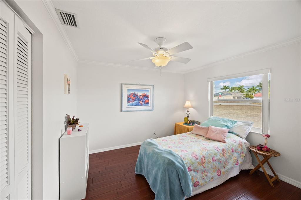 26223 Barcelos Court Punta Gorda, FL 33983 - Photo 22 of 34 a bedroom with a bed and a chandelier