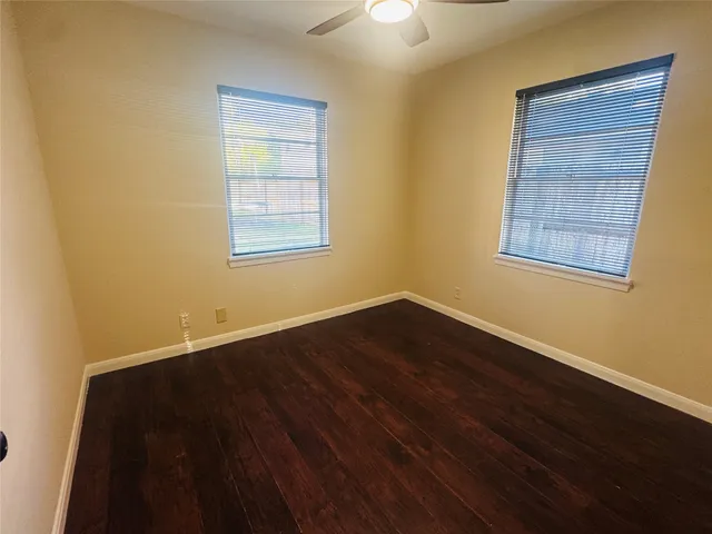 an empty room with wooden floor and closet area