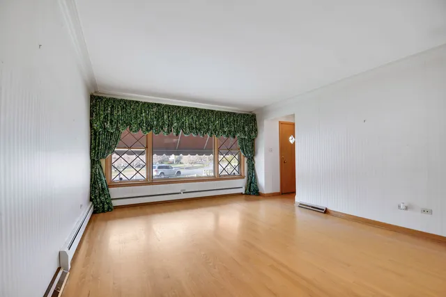 a view of a room with wooden floor a fireplace and a window