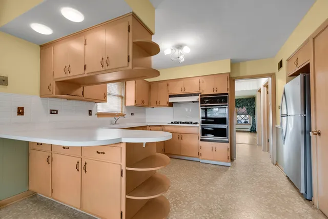 a kitchen with stainless steel appliances a stove refrigerator sink and cabinets