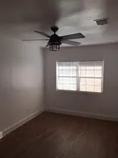 en empty room with windows and ceiling fan