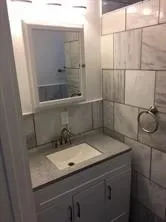 a bathroom with a granite countertop sink and mirror