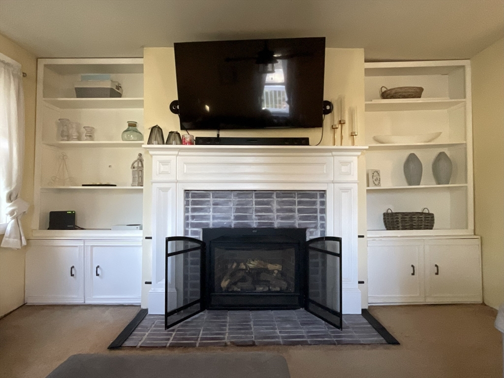 9 Watt Road Worcester, MA 01606 - Photo 16 of 36 a living room with a fireplace and a flat screen tv