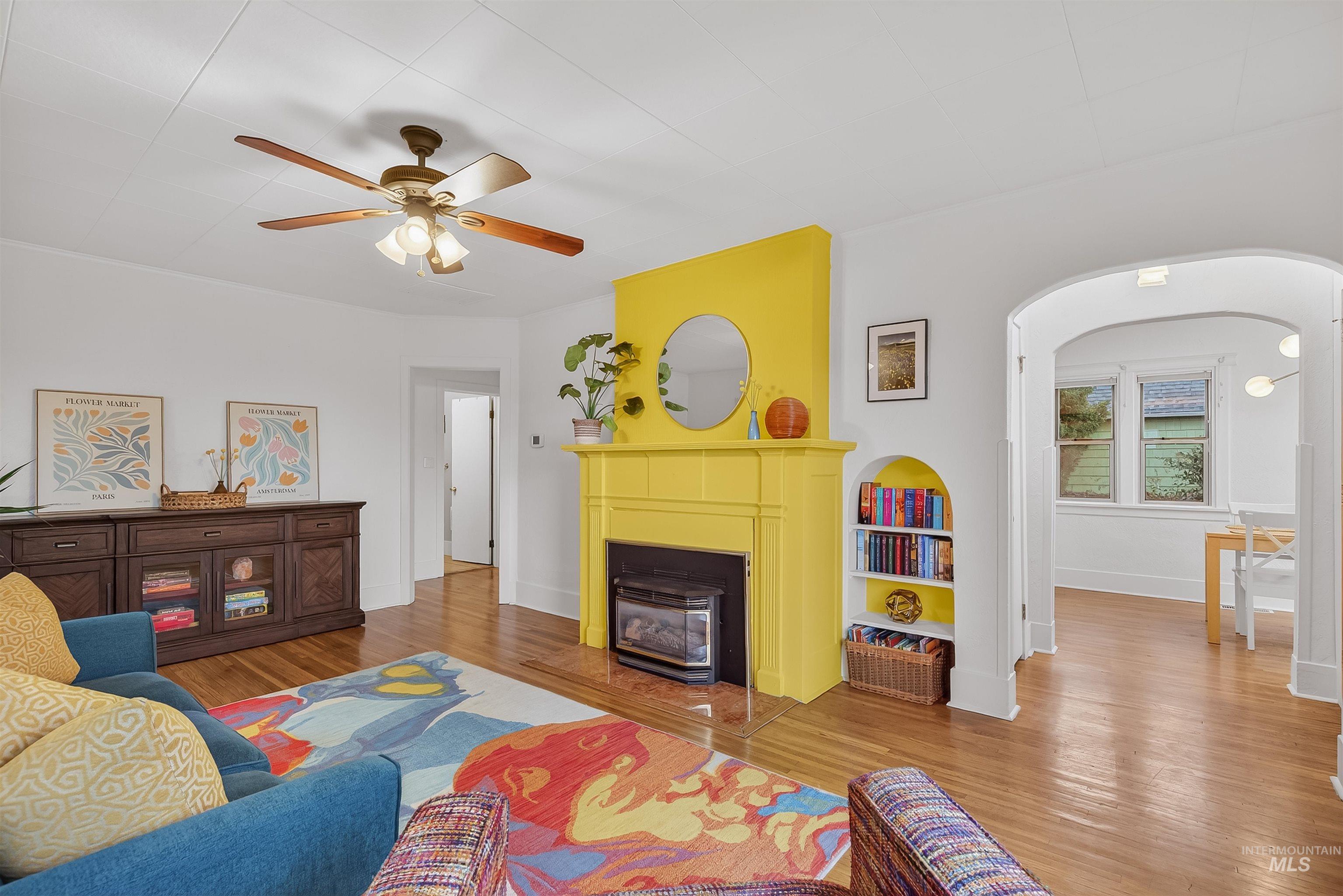 1209 3rd Street Lewiston, ID 83501 - Photo 3 of 49 Living room with arched walkways, light wood-style flooring, a wood stove, and ceiling fan