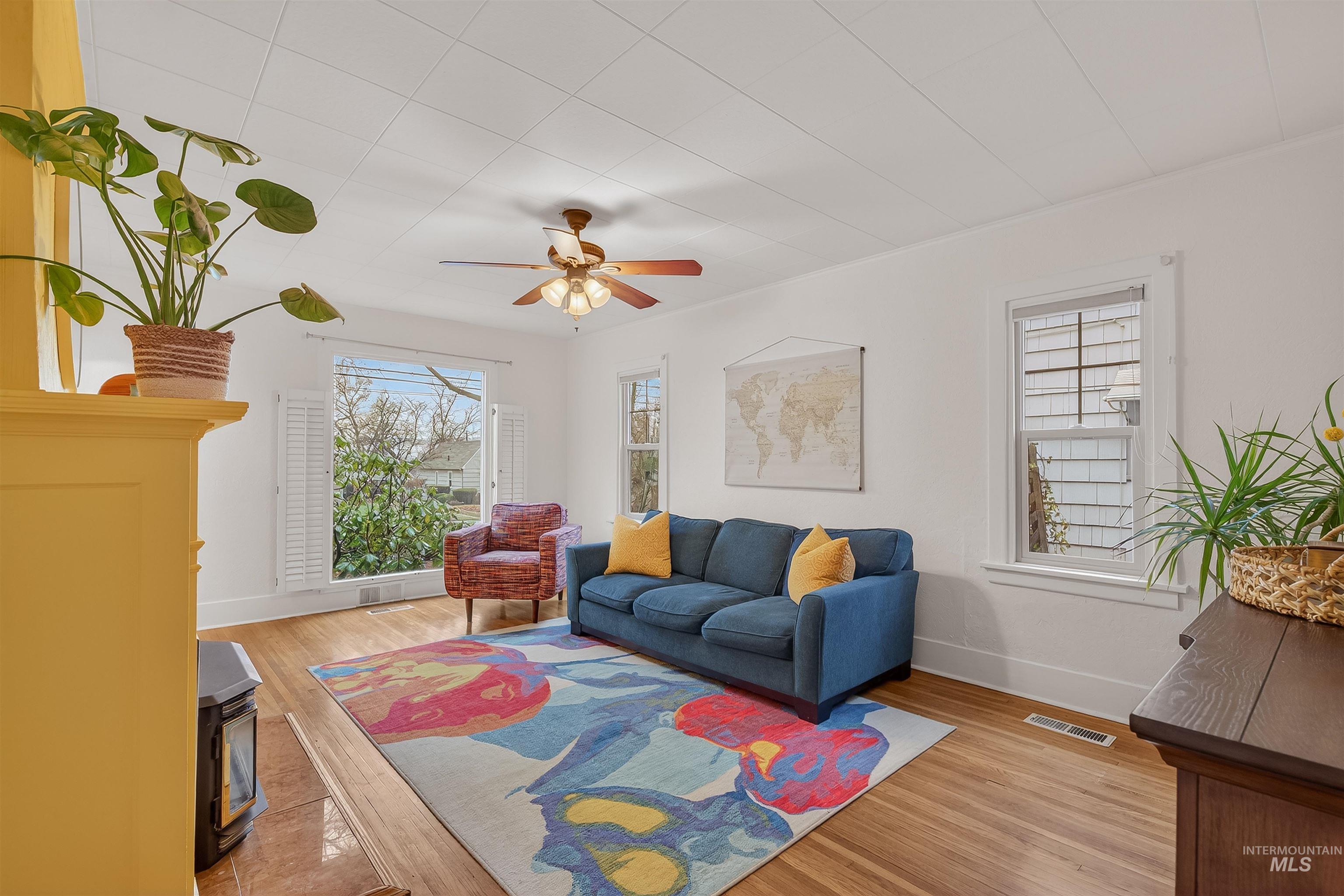 1209 3rd Street Lewiston, ID 83501 - Photo 8 of 49 Living room with a wood stove, light wood-style flooring, plenty of natural light, and a ceiling fan