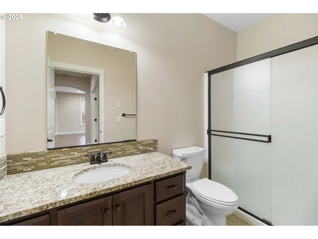 a bathroom with a granite countertop sink toilet and shower