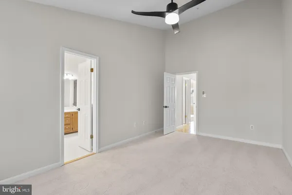 an empty room with a ceiling fan and bathroom