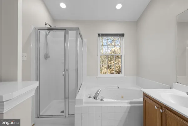 a bathroom with a tub a sink and a window