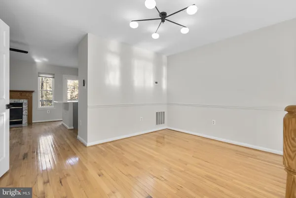 wooden floor in an empty room with a kitchen