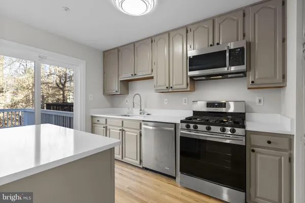 a kitchen with stainless steel appliances a stove a sink and a microwave