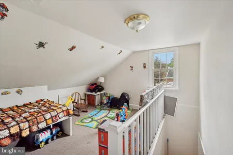 a bedroom with baby crib and a window