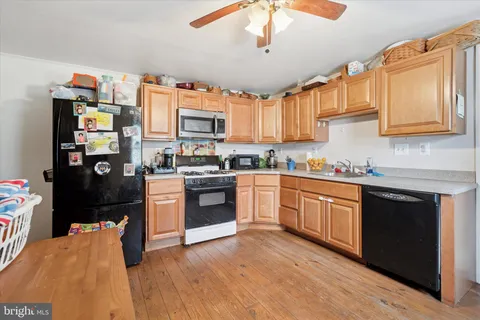 a kitchen with stainless steel appliances granite countertop a refrigerator a stove top oven a sink and dishwasher