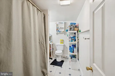 a white bath tub sitting next to a white toilet and a shower curtain