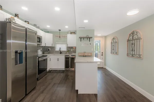 a kitchen with stainless steel appliances granite countertop a refrigerator stove top oven and sink