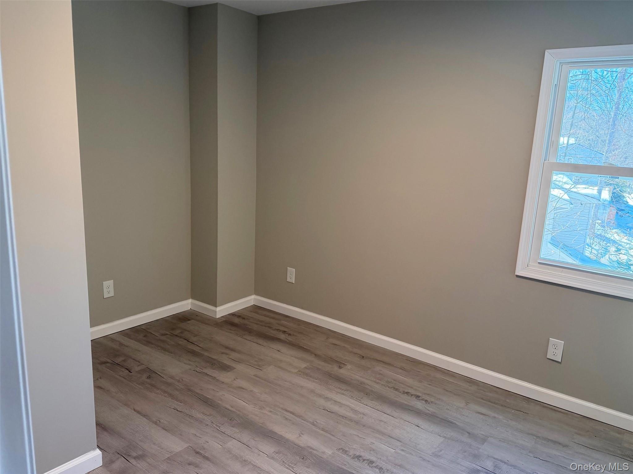 9 Underhill Trail Monroe, NY 10950 - Photo 8 of 18 a view of an empty room with wooden floor and a window